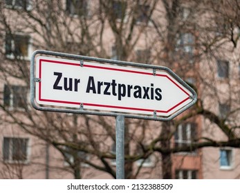 Guiding Sign With Letters On It Pointing To A Medical Practice. Large Frame With A Board In A Residential District In Germany. Arrow Sign Showing The Way To The Doctor.