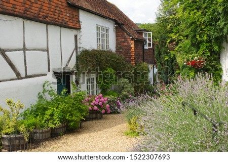 Guildford, England - August 2, 2019: Whitewashed and tile Cottage at Shere in Surrey.