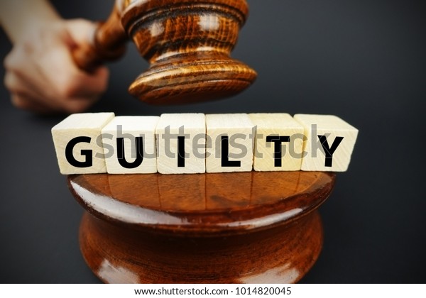 Guilty court decision with judge gavel and wooden\
cubes with text\
