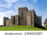 Guimaraes Castle in Guimaraes, Portugal, a hilltop Romanesque castle, founded in the 1000s and birthplace of Afonso Henriques against a clear blue sky