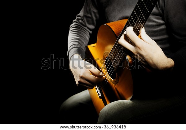 Guitar acoustic\
guitarist classical guitar player hands close up. Spanish guitar\
music instrument isolated on\
black