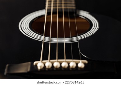 Guitar black, string instrument, six strings stretched, polished smooth soundboard, lower threshold, close-up macro, selective focus