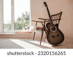 Guitar. Guitar chords. Acoustic guitar. Music. Musical background. An image of an acoustic guitar in a room with a retro armchair. Hard light. Shadows.