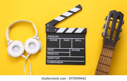 Guitar, Clapperboard And Headphones On A Yellow Background. Musical And Movie Concept 