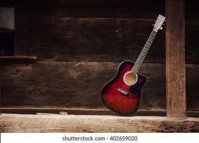 guitar leaning on a old wooden porch