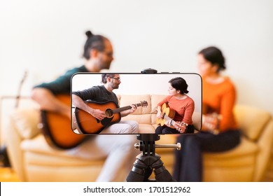 Guitar Lessons Tutorial With Smart Phone. Indoor Screen Shot Of Musical Course. Technology And Leisure. Professor Teaching How To Play An Instrument. Video Screen Recording Music Online Class At Home.