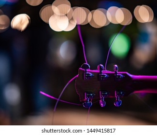 Guitar With Long Strings With Bokeh Patio Lights In Background