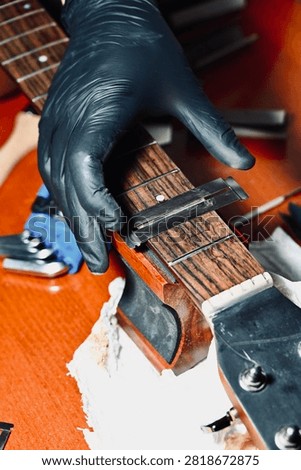 Guitar Luthier Testing Newly Installed String on Rosewood Fretboard Close Up