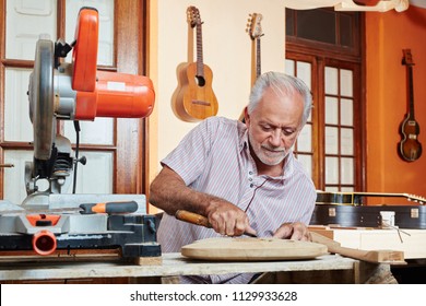 Guitar maker or luthier working with chisel 