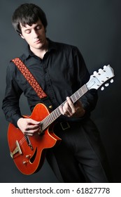 Guitar Man. Guitarist Playing Six-string Electric Red Guitar. Black Background.