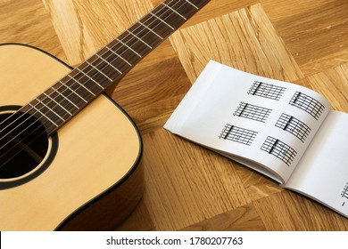 Guitar and notebook on a wooden surface. Music sheets. Concept of music. 