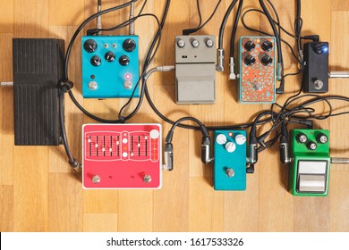 Guitar Pedalboard On The Floor Of A Recording Studio. Generic Guitar Effects On The Wooden Floor. Guitar Recording, Rock Music Creation Concept