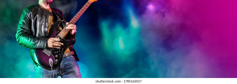 Guitar player performs on stage. Rock guitarist plays solo on an electric guitar. Artist and musician performs like rockstar. Black and white version. Green and pruple version. Panoramic image.