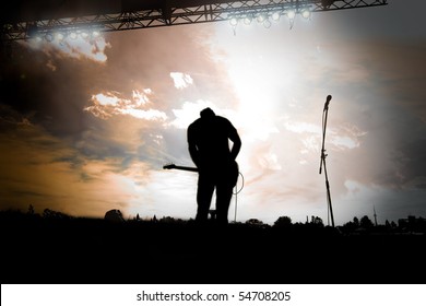 Guitar Player Playing A Outdoor Concert At Sunset