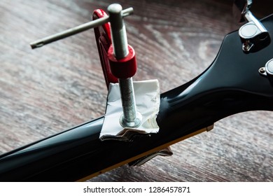 Guitar Repair. Broken And Cracked Guitar Neck Is Glued In And Tightened With A Clamp.