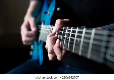 Guitarist Man Playing Guitar, A Man Sitting And Practicing Electric Guitar On Dark Background