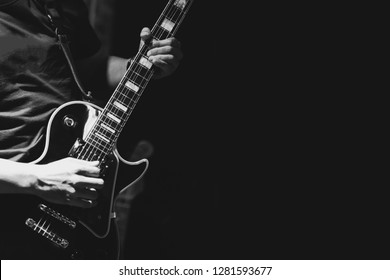 Guitarist on stage for background, soft and blur concept. Close up hand playing guitar. young musician playing guitar, live music background.Band performs on stage, rock music concert.