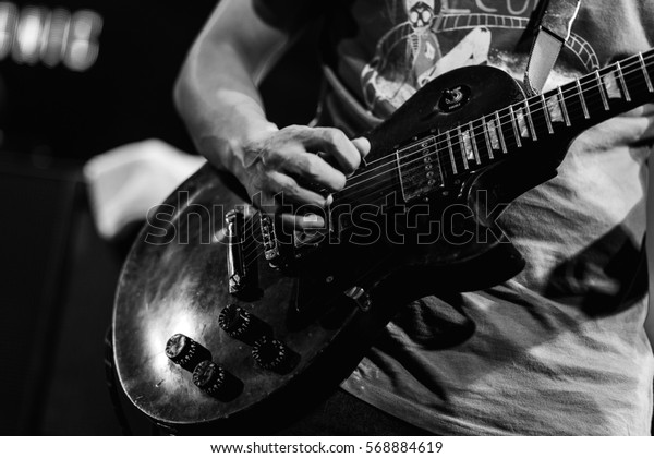 The guitarist is playing guitar\
, guitar background , music background , black  and white\
guitar