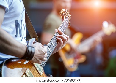 Guitarist playing live concert with rock band.