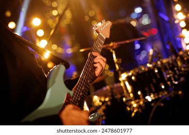 A guitarist plays a chord on an electric guitar during a rock band performance