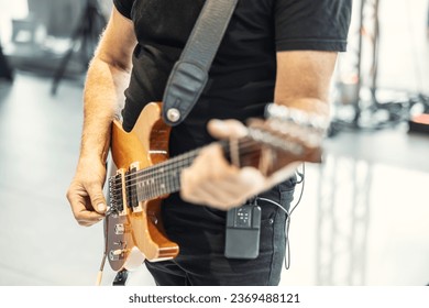 Guitarists play at a rock or rock n roll concert. A guitarist plays chords on an electric guitar.