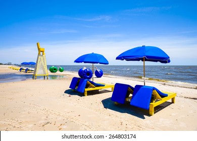 Gulf coast beach in Biloxi, Mississippi with water tricycles and lounge chairs.