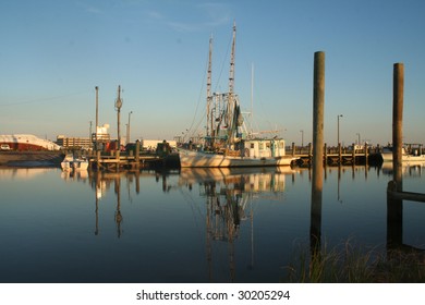 Gulf Coast Shrimp Boat At Harbor With Reflections On Calm Ocean Waters