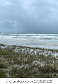 Gulf Of Mexico Water As Tropical Storm Cristobal Approaches With Two People Standing In The Water At A Distant View