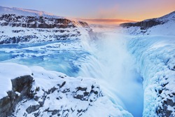 The Gullfoss Falls In Iceland In Winter When The Falls Are Partially Frozen. Photographed At Sunset.