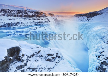 The Gullfoss Falls in Iceland in winter when the falls are partially frozen. Photographed at sunset.