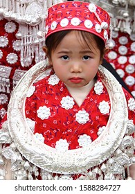 Gulong, China - October 25, 2019: At Lusheng Festival, portrait of a female child, wearing typical clothes and headgear of Miao minority 