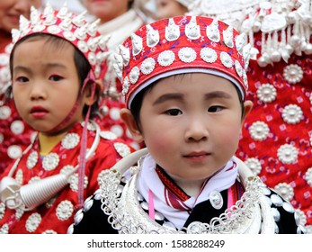 Gulong, China - October 25, 2019: At Lusheng Festival, portrait of children, wearing typical clothes and headgear of Miao minority 