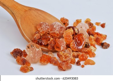 Gum arabic on wooden spoon, white background.Selective focus. 