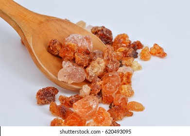 Gum arabic on wooden spoon, white background.Selective focus. 