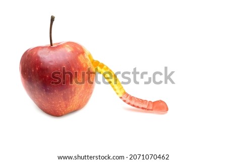 Gummy worm coming out of a fresh red apple isolated on white