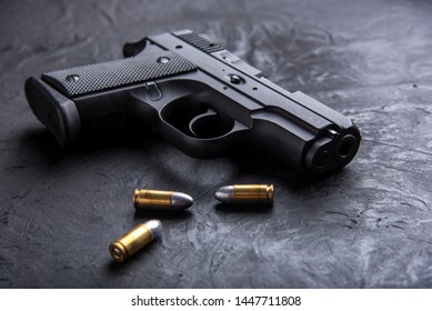 Gun with ammunition on dark background.