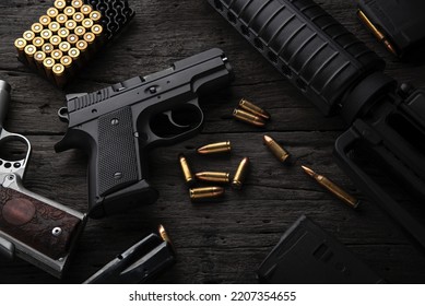 Gun with ammunition on dark wooden background.