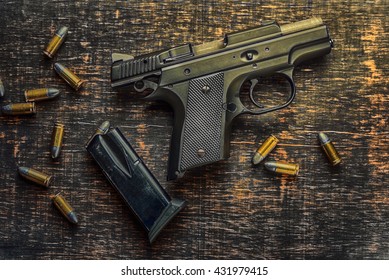 Gun With Bullets On Wooden Background