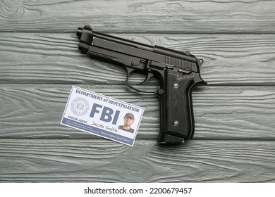 Gun With Document Of FBI Agent On Wooden Background