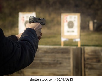 Gun In Girl's Hands On Shooting Range