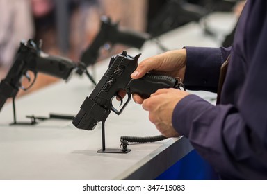 Gun In His Hand. Exhibition And Sale Of Weapons