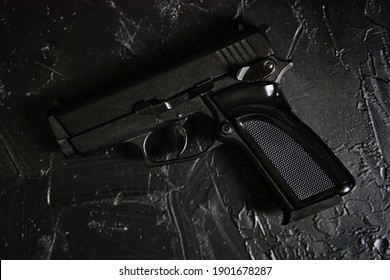 Gun on black texture table. Ammunition of law enforcement agencies. Pistol for cop. Firearm for defense or attack.
