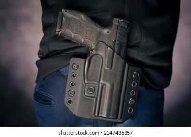 The gun is placed in a holster at the belt