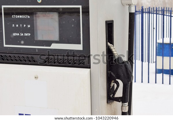 gun\
for refueling at a gas station on a winter frosty\
day