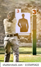 Gun Shooting Competition. Lady Shooting With Gun At Target In Shooting Range.