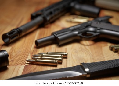 Guns with ammunition on wooden background.