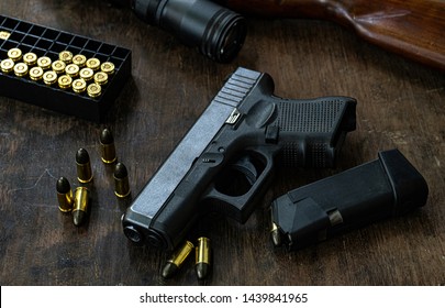 Guns and ammunition placed in a wooden table,Short guns and ammunition placed on a black background table,Guns and ammunition are ready to use.,Noisy weapon