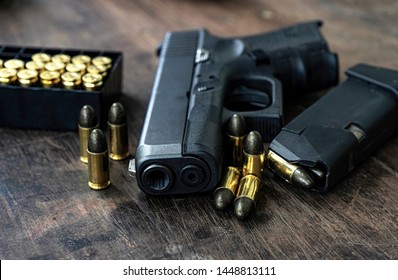 Guns and ammunition placed in a wooden table,Short guns and ammunition placed on a black background table,Guns and ammunition are ready to use.,Noisy weapon