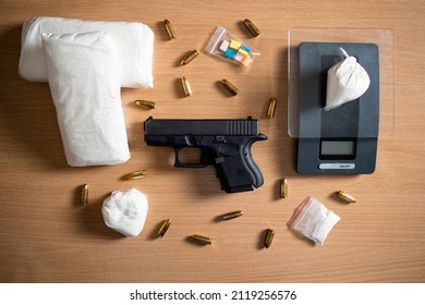 Guns And Drugs Concept - Top View Of Cocain Packages, Scale And Gun With Bullets. Narcotics Street Distribution.