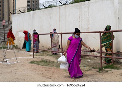 Gurgaon, Delhi, India - Circa 2020 : Underprivileged Women In Sarees Stand In A Ilne Following The Social Distancing Norms To Collect Food Rations At A Donation Drive. The Coronavirus Pandemic